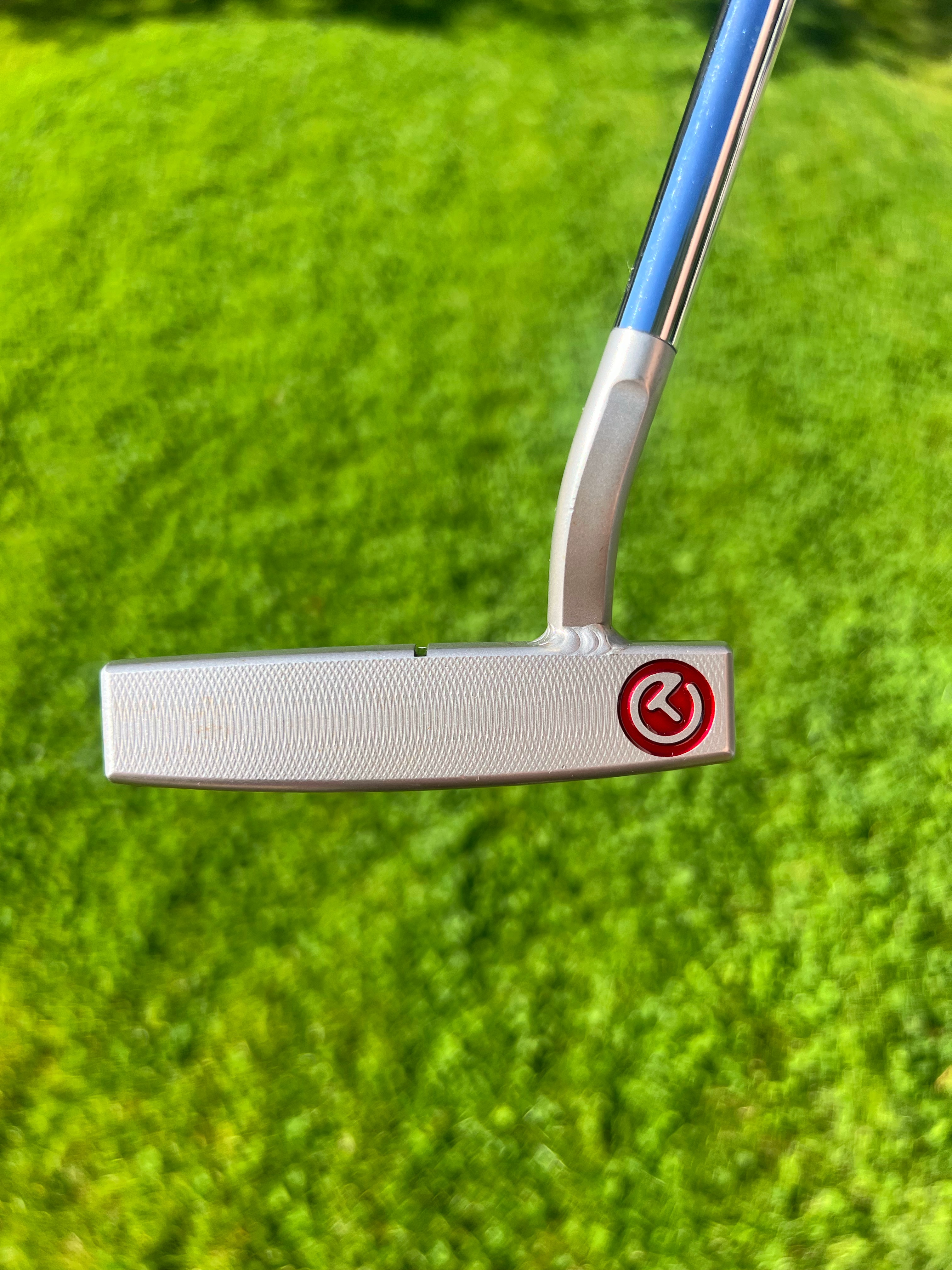 Scotty Cameron putter on dark wood deck at golden sunset